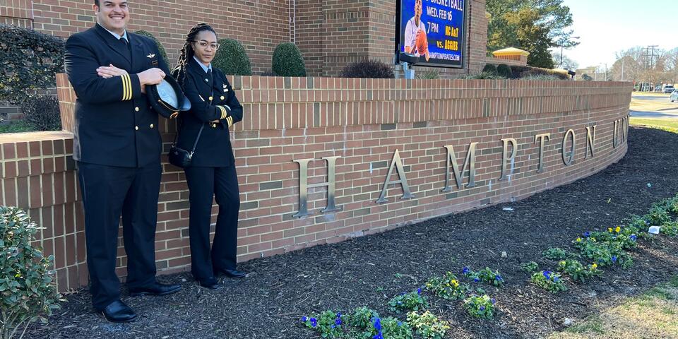 Two aviators stand outside of Hampton University.